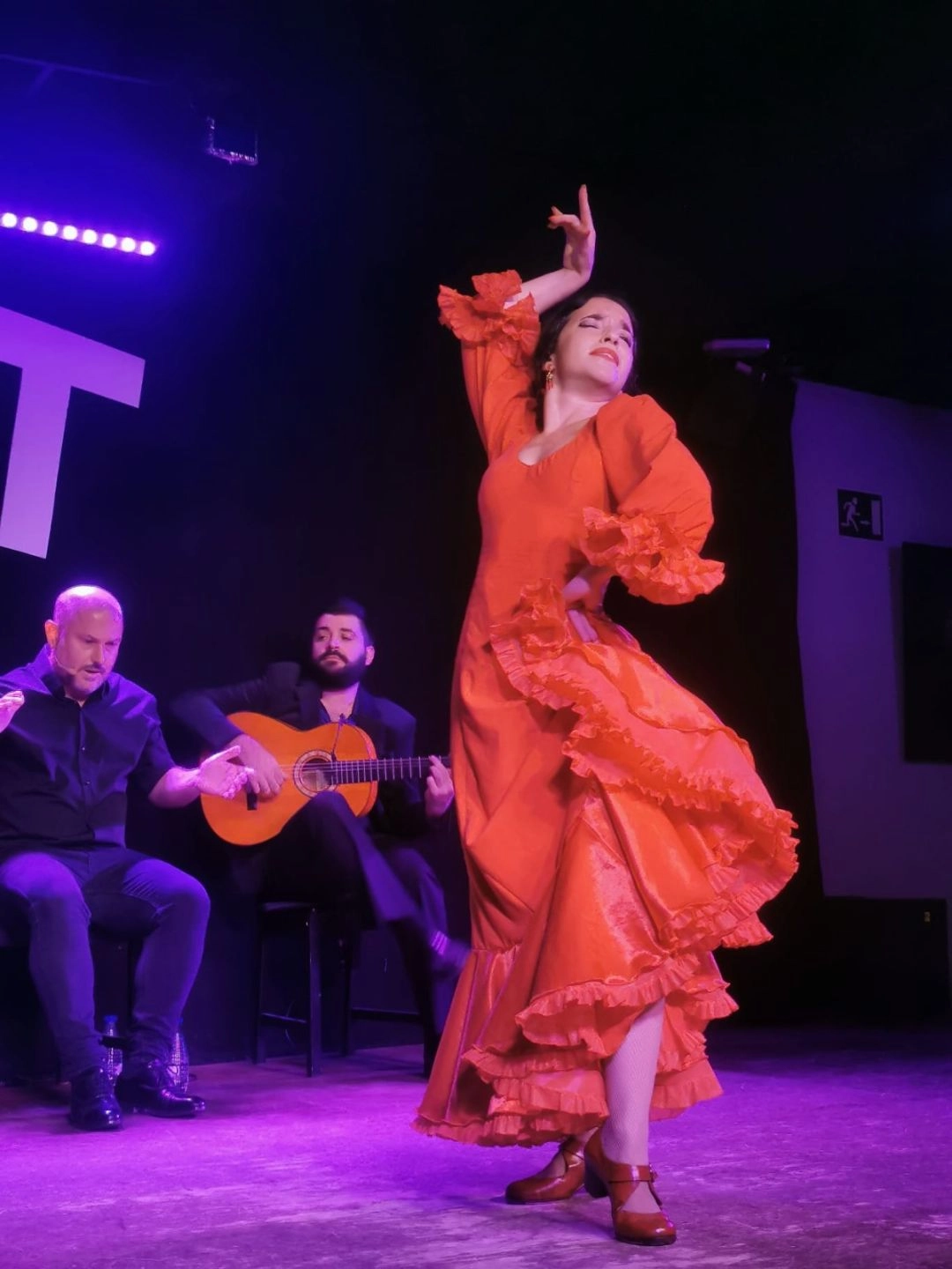 Isabel Alarcón tańczy flamenco w czerwonej sukni na scenie podczas koncertu