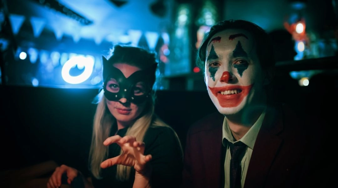 Para w halloweenowych maskach i makijażu podczas nocnej imprezy w Warszawie.