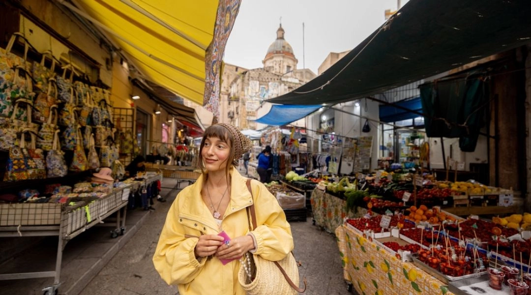 Podróżniczka na lokalnym targu w mniejszym mieście, codzienne zakupy i spokojne tempo podróży.