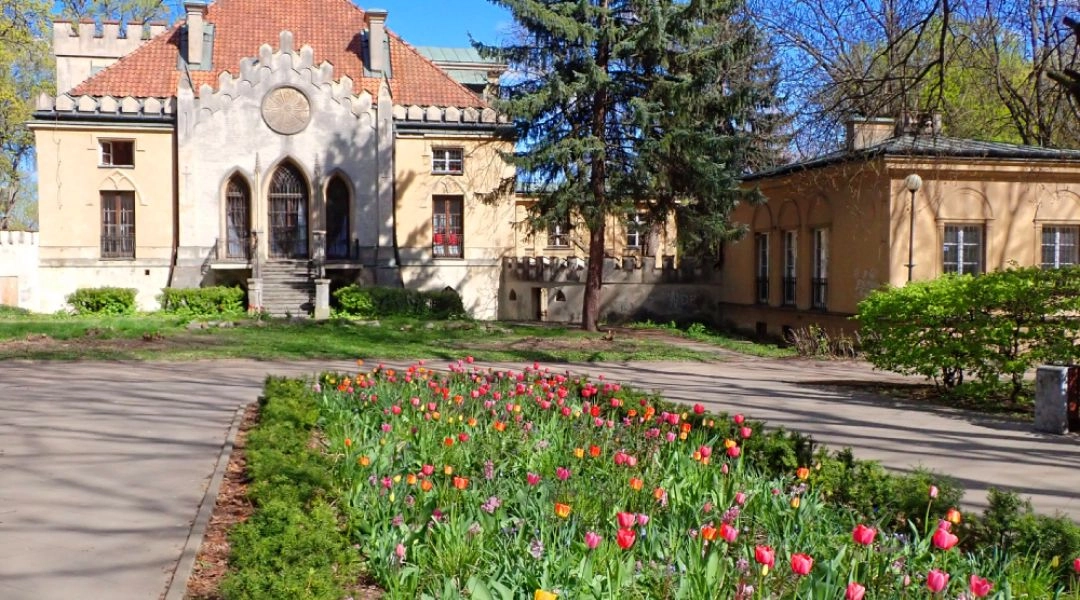 Pałacyk Szustrów w parku Morskie Oko w Warszawie, z wiosennymi tulipanami przed budynkiem.