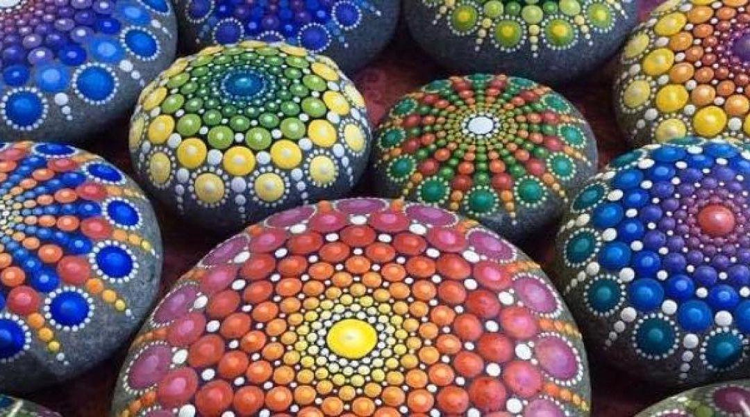 Kolorowe kamienie ręcznie malowane w kropkowe, mandalowe wzory w różnych barwach.