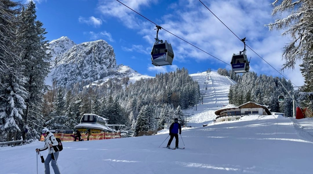 Narciarz przy gondoli w ośrodku narciarskim w regionie Innsbrucka, w tle ośnieżone Alpy