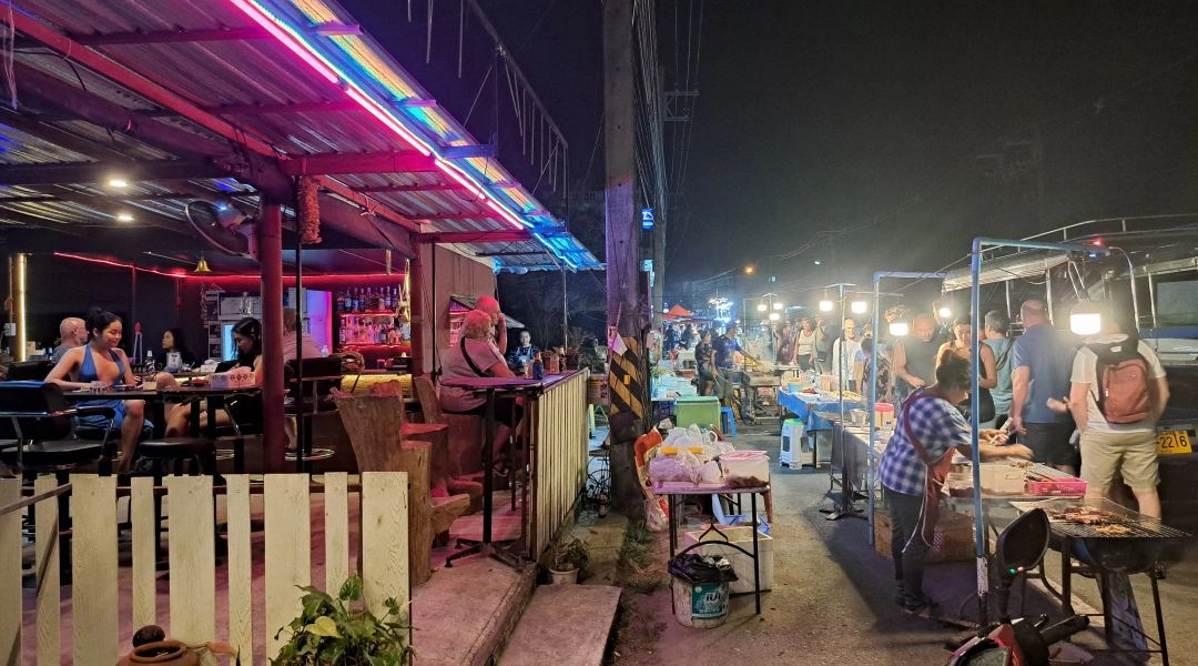 Nocny street food w Tajlandii, targ z jedzeniem, lokalna kuchnia tajska po zmroku.