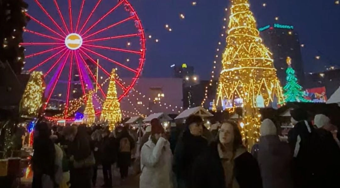 Świąteczny jarmark na placu Defilad w Warszawie nocą: choinka, diabelski młyn i iluminacje zimą.