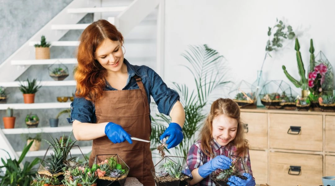 Mama i córka podczas warsztatów ekologicznych w Warszawie, wspólnie sadzą rośliny w doniczkach.