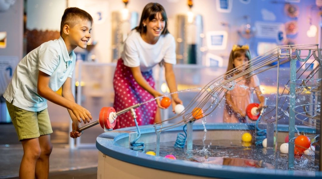 Dzieci bawiące się przy wodnych eksperymentach w Centrum Nauki Kopernik w Warszawie.