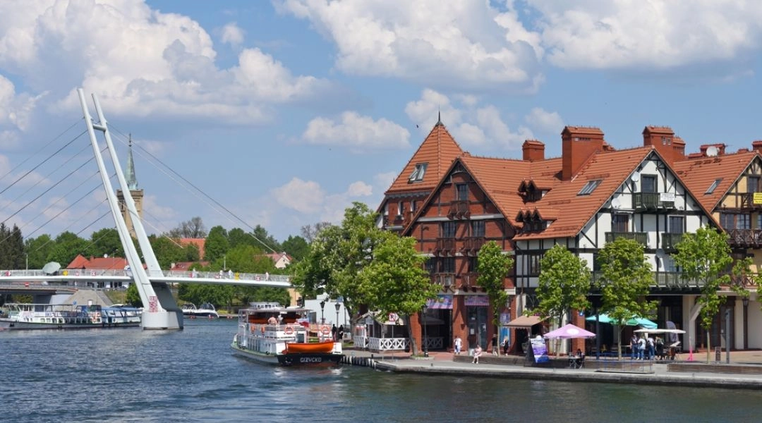 Mikołajki na Mazurach z mostem nad przesmykiem łączącym Jezioro Mikołajskie i Tałty oraz promenadą nad wodą.