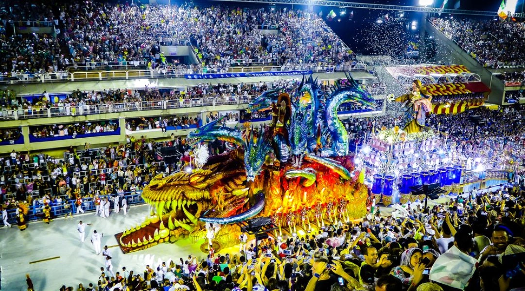 Platforma paradna szkoły samby na Sambodromie w Rio de Janeiro, tłumy widzów i ogromna scenografia karnawałowa.