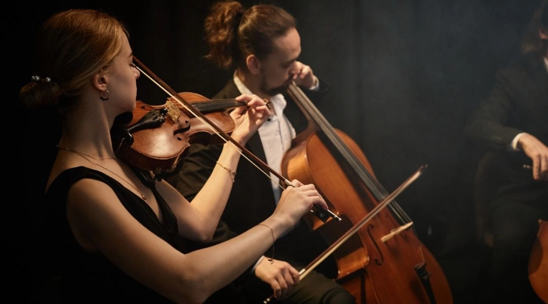 III Festiwal Klasyka Warszawy koncert w Teatrze Królewskim Łazienki Królewskie, muzycy grający na skrzypcach i wiolonczeli podczas wieczornego występu