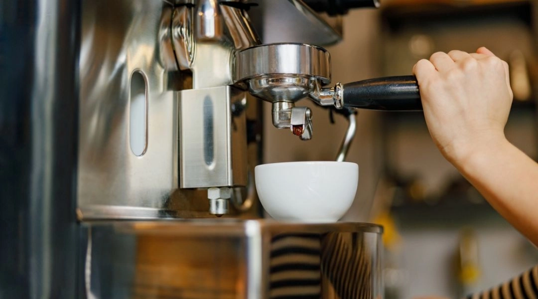 Barista przygotowuje espresso podczas festiwalu kawy w Warszawie, ekspres i filiżanka.