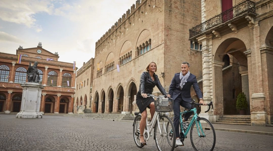 Para jedzie na rowerach przez historyczne centrum Rimini w Emilii-Romanii.