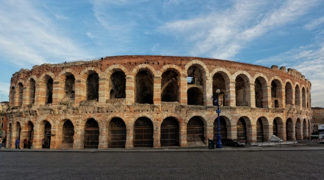 Rzymska Arena w Weronie z charakterystycznymi arkadami widziana z placu przed amfiteatrem.