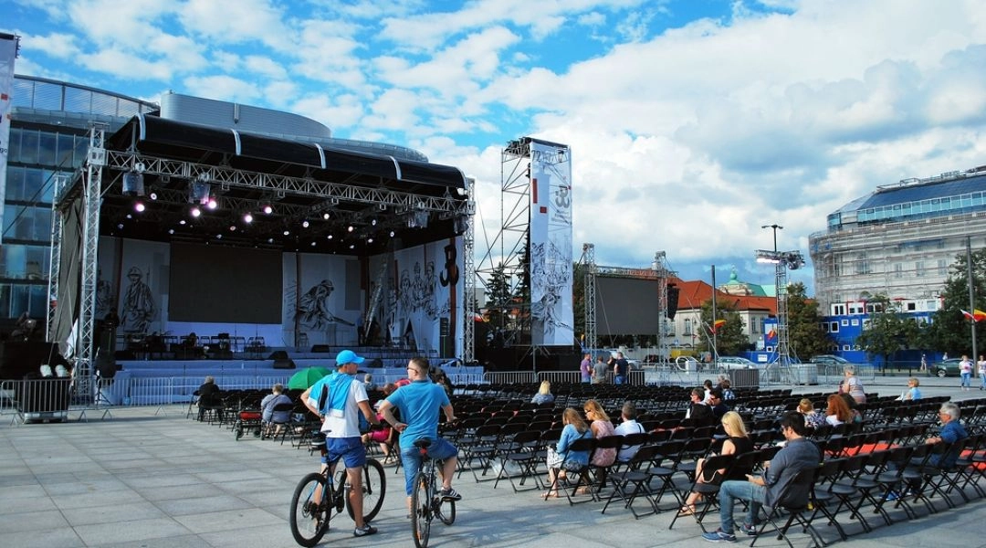 Scena i rzędy krzeseł przygotowane na placu Piłsudskiego przed koncertem rocznicowym Powstania Warszawskiego.