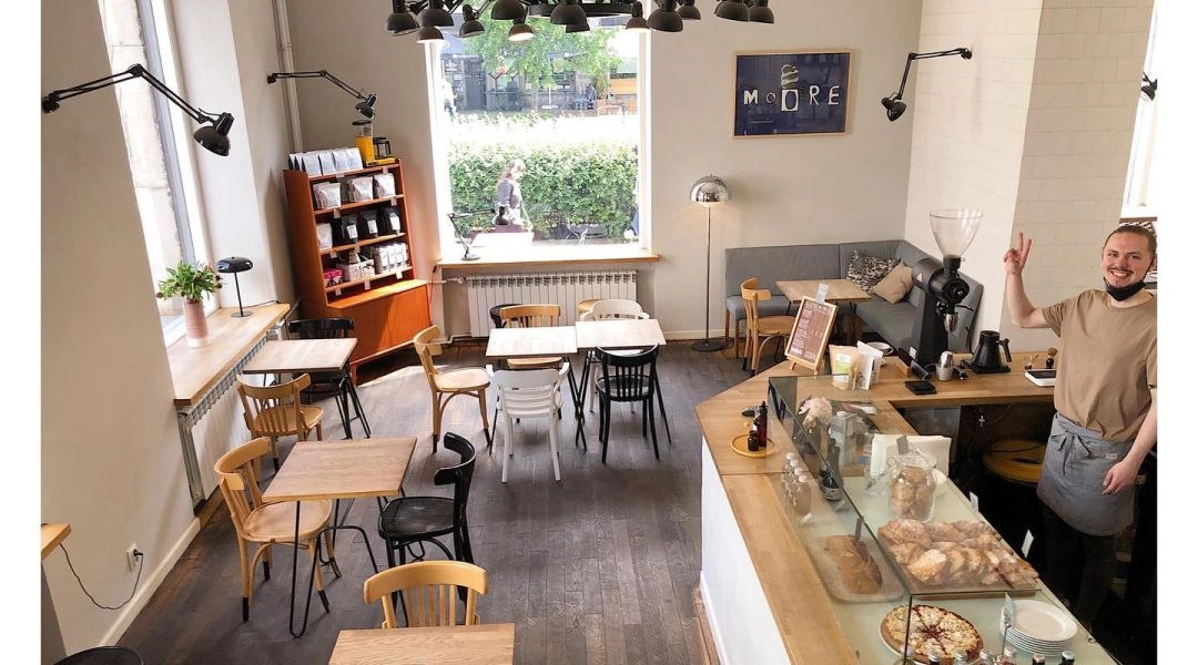 Wnętrze Ministerstwa Kawy w Warszawie z półkami kaw i akcesoriów.