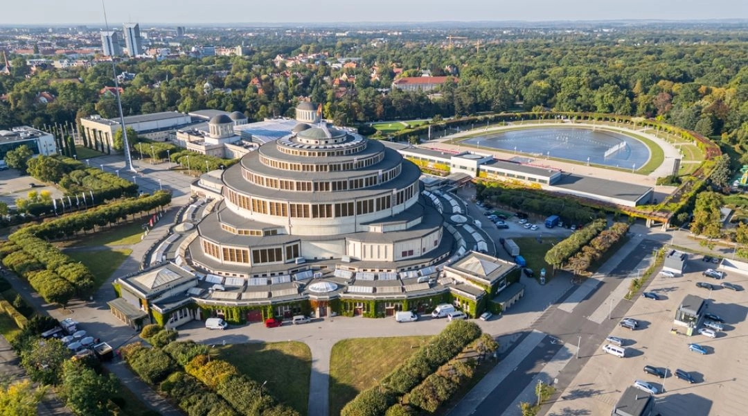 Hala Stulecia widziana z lotu ptaka, z Pergolą, Fontanną Multimedialną i zielenią Parku Szczytnickiego w tle.