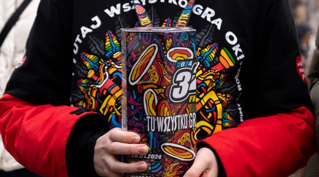 Wolontariusz Wielkiej Orkiestry Świątecznej Pomocy trzymający puszkę kwestarską.