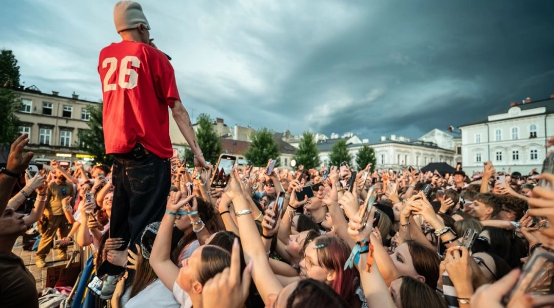 Uczestnik koncertu  w czerwonej koszulce i publiczność podczas koncertu na placu w Bielsku-Białej.