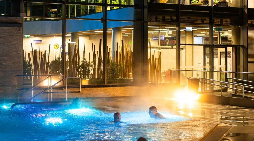 Zewnętrzny basen Termy Poddębice zimą, para unosząca się nad wodą i oświetlona strefa SPA.