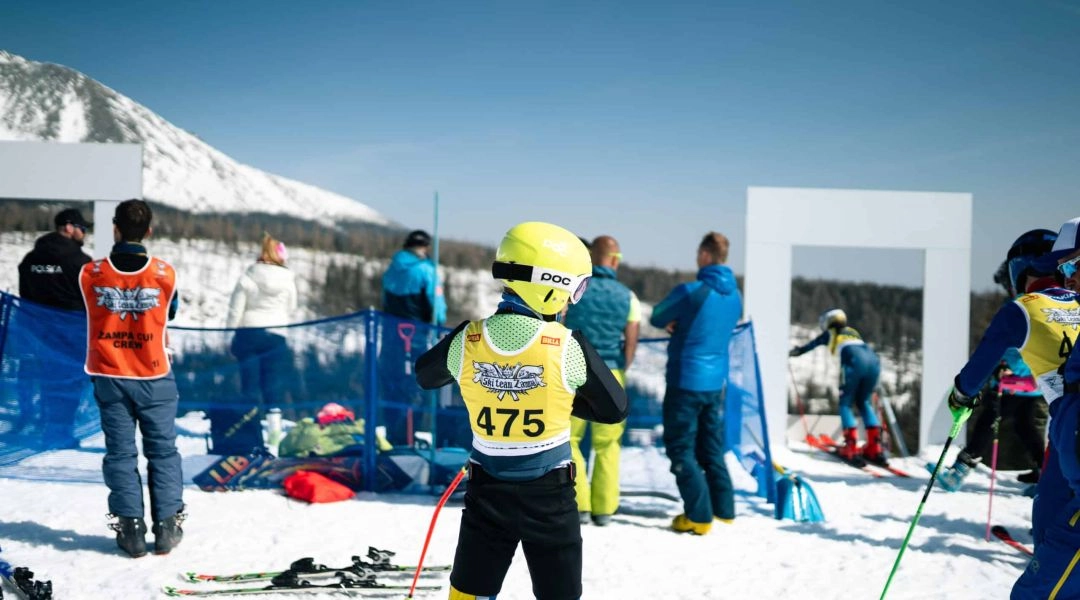 Młodzi zawodnicy w numerach startowych przygotowują się do startu w zawodach narciarskich Billa Žampa Cup.