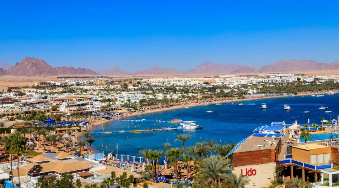Panorama zatoki Naama Bay w Szarm el-Szejk z plażami, hotelami, łodziami i górami Synaju w tle.