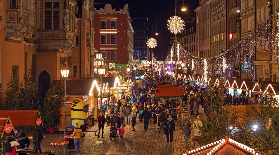 Wrocławski Rynek zimą, jarmark świąteczny z iluminacjami, choinką i straganami.