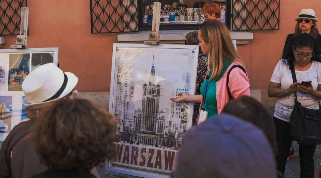 Przewodniczka opowiadająca grupie turystów o historii Warszawy podczas miejskiego spaceru