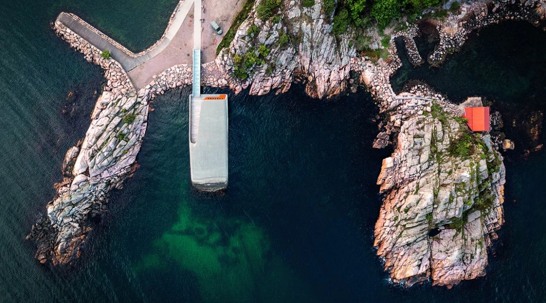 Restauracja Under w Lindesnes w Norwegii widziana z lotu ptaka, częściowo zanurzona w morzu