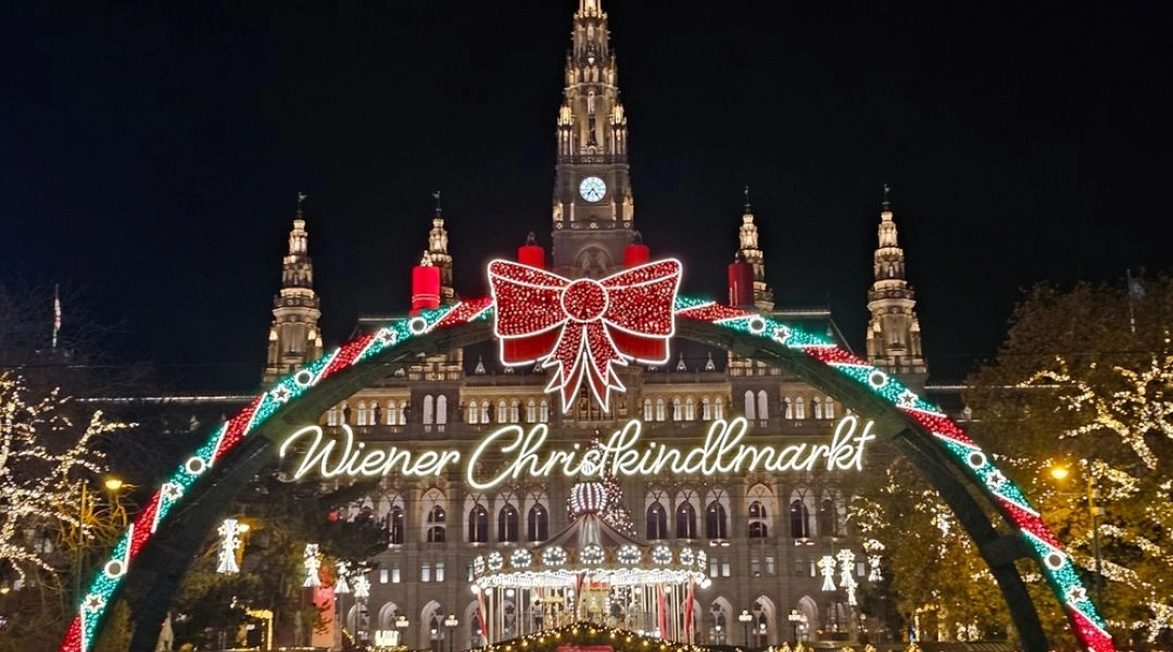 Wiedeń w okresie świątecznym, Wiener Christkindlmarkt przed ratuszem z iluminacjami i tłumem odwiedzających.