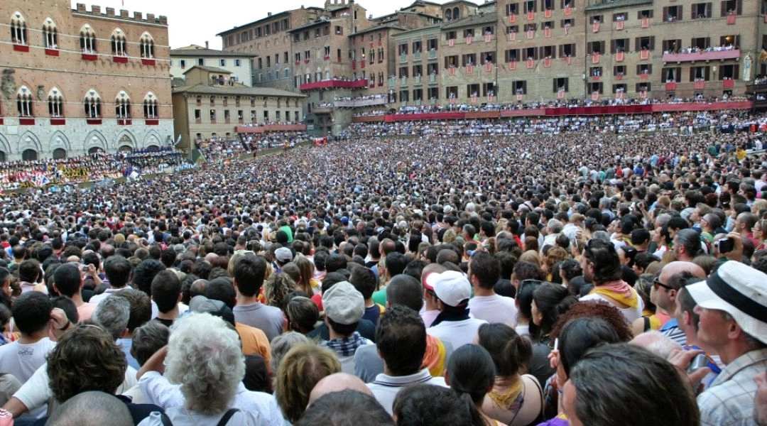 Tłum widzów zgromadzonych na Piazza del Campo przed wyścigiem Palio di Siena.