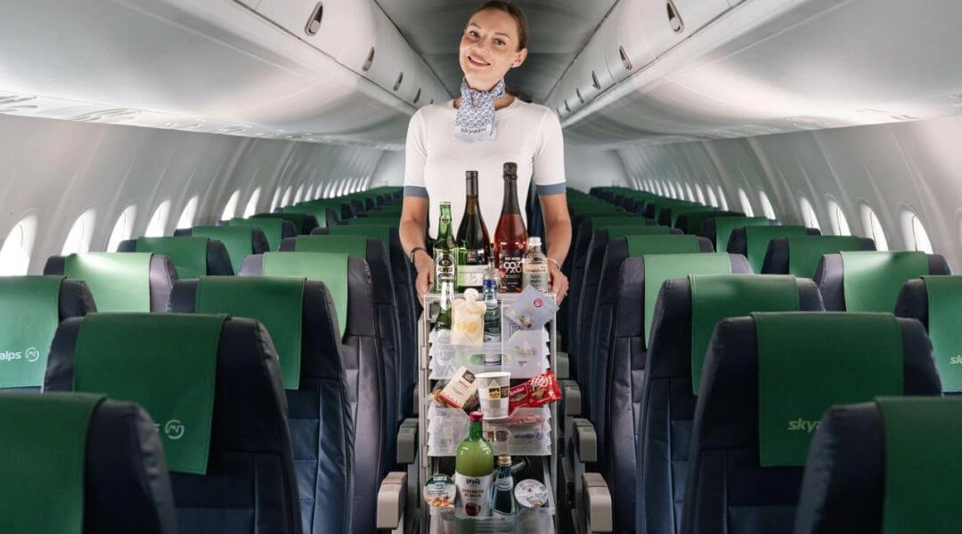 Stewardesa na pokładzie samolotu serwująca wino