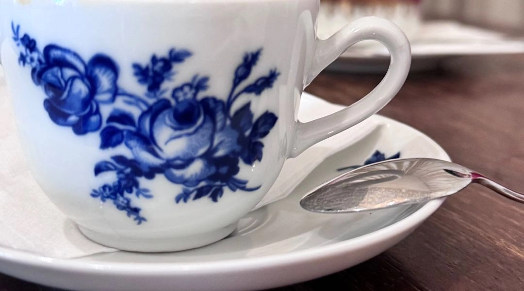 Filiżanka kawy w białej porcelanie z niebieskim wzorem, podana w jednej z kawiarni w Bratysławie.