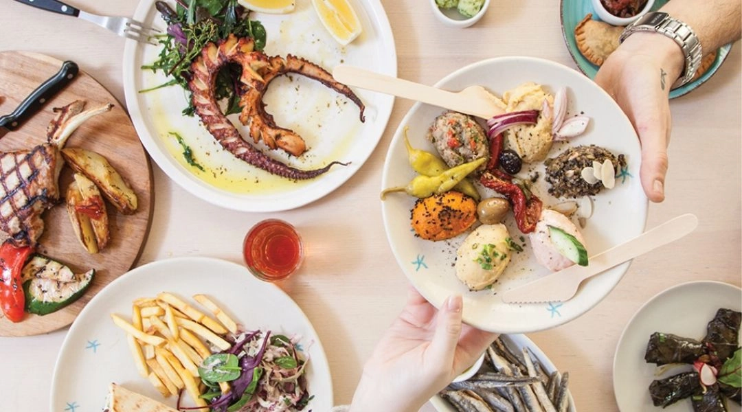 Stół z daniami w Meltemi, ośmiornica, greckie pasty, grillowane mięso i pita