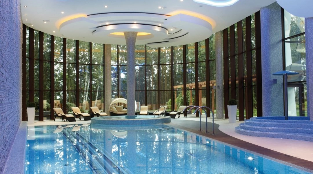 Basen w Hotelu Narvil Conference & Spa w Serocku z dużymi przeszkleniami i leżankami wodnymi.