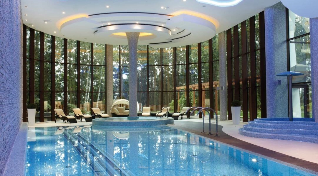 Basen w Hotelu Narvil Conference & Spa w Serocku z dużymi przeszkleniami i leżankami wodnymi.