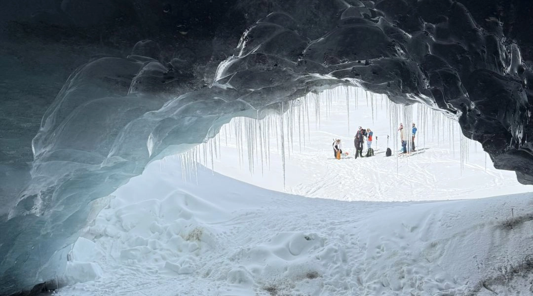 Lodowa jaskinia Val Senales, wnętrze lodowca z naturalnym światłem i uczestnikami wycieczki