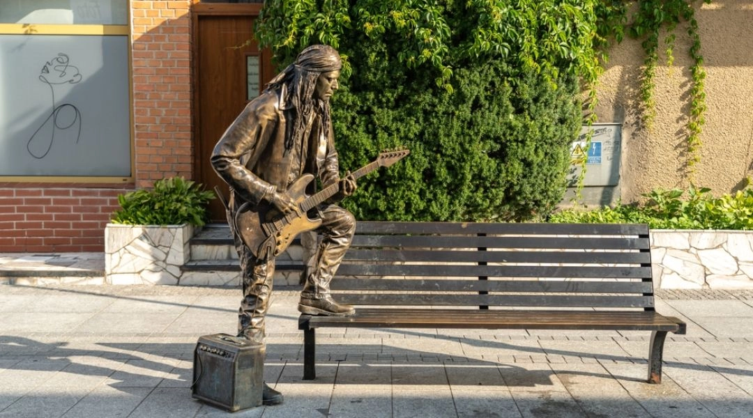 Rzeźba bluesmana z gitarą na ławce przy ulicy Chłodnej w Suwałkach.