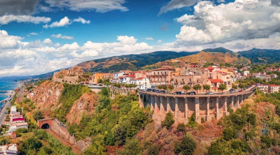 Panorama Scilli z klifem, zabudową na wzgórzu i widokiem na Morze Tyrreńskie.