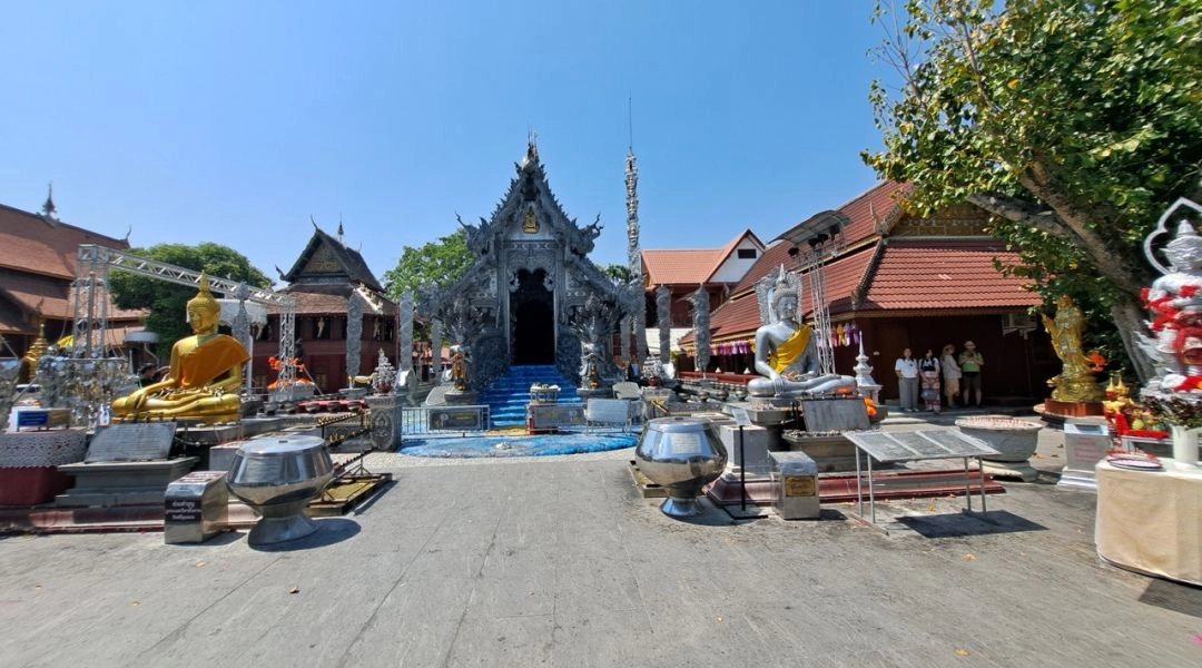 Dziedziniec Srebrnej Świątyni Wat Sri Suphan w Chiang Mai z posągami Buddy.