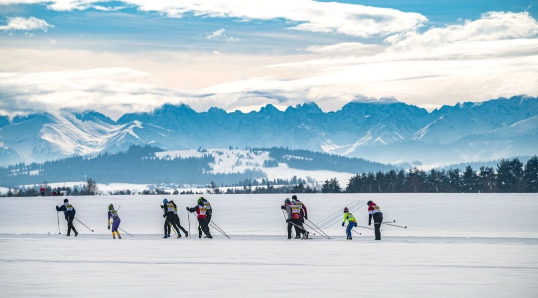 Zimowa trasa Biegu Podhalańskiego w Nowym Targu, biegacze poruszający się po śniegu na tle Tatr