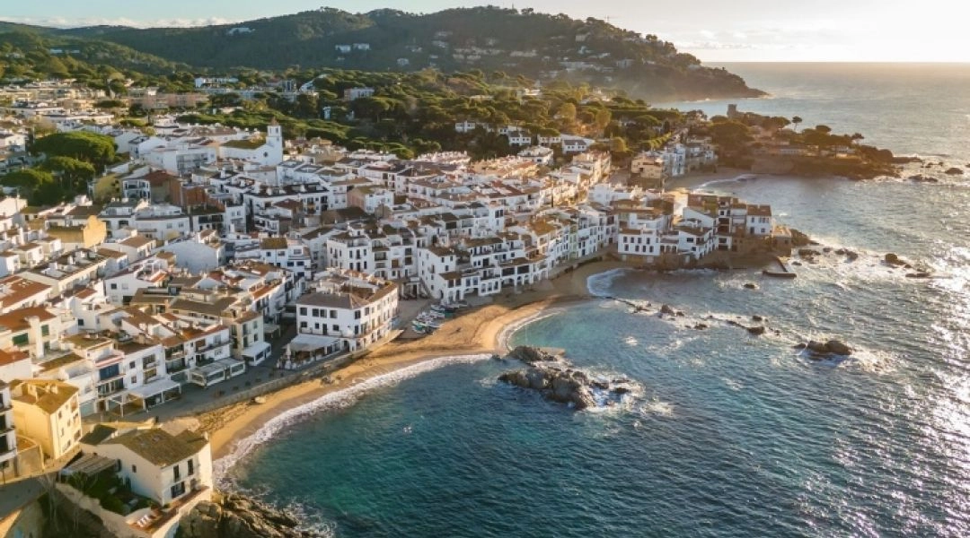 Białe nadmorskie miasteczko na Costa Brava widziane z góry nad zatoką