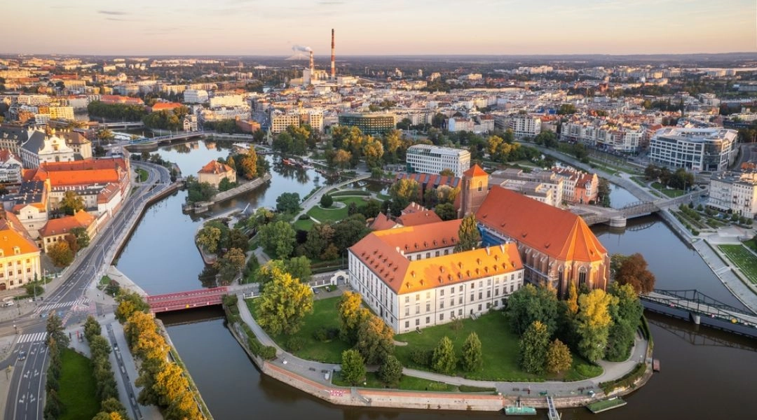 Widok z lotu ptaka na Wyspę Piasek we Wrocławiu, kościół Najświętszej Marii Panny na Piasku, Odrę i otaczające wyspę mosty.