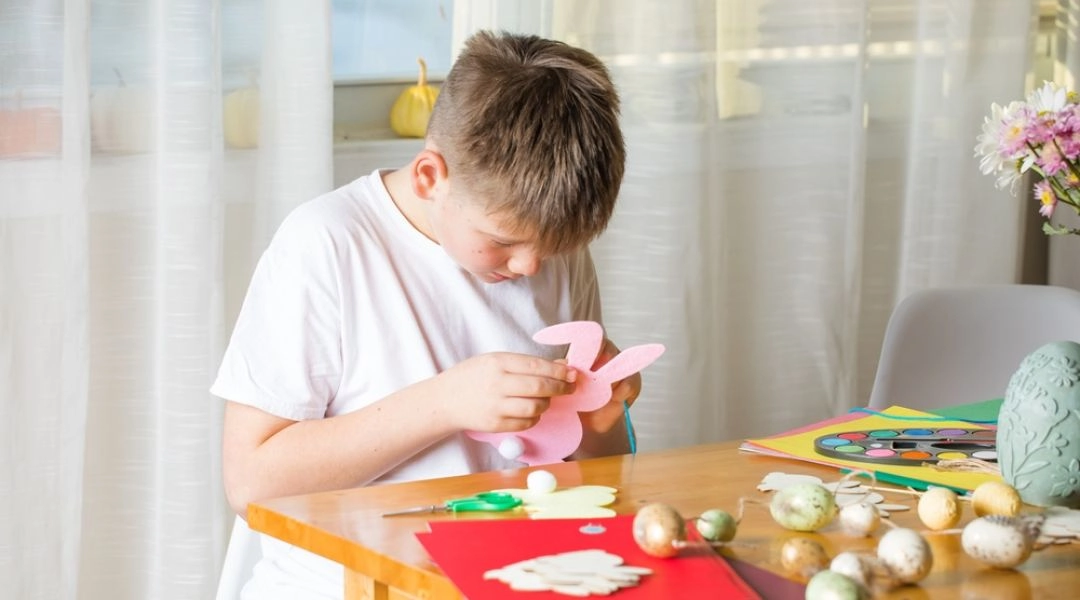 Dziecko przygotowuje dekoracje wielkanocne podczas warsztatów w Warszawie.