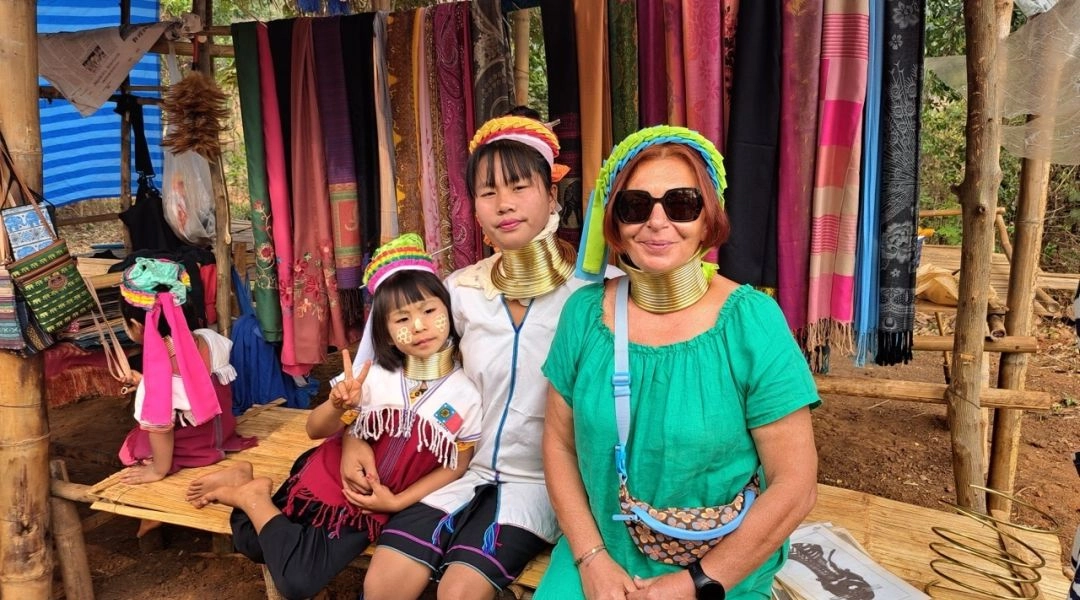 Kobiety i dziewczynki z plemienia Padaung w północnej Tajlandii, noszące mosiężne obręcze na szyi, w wiosce turystycznej.