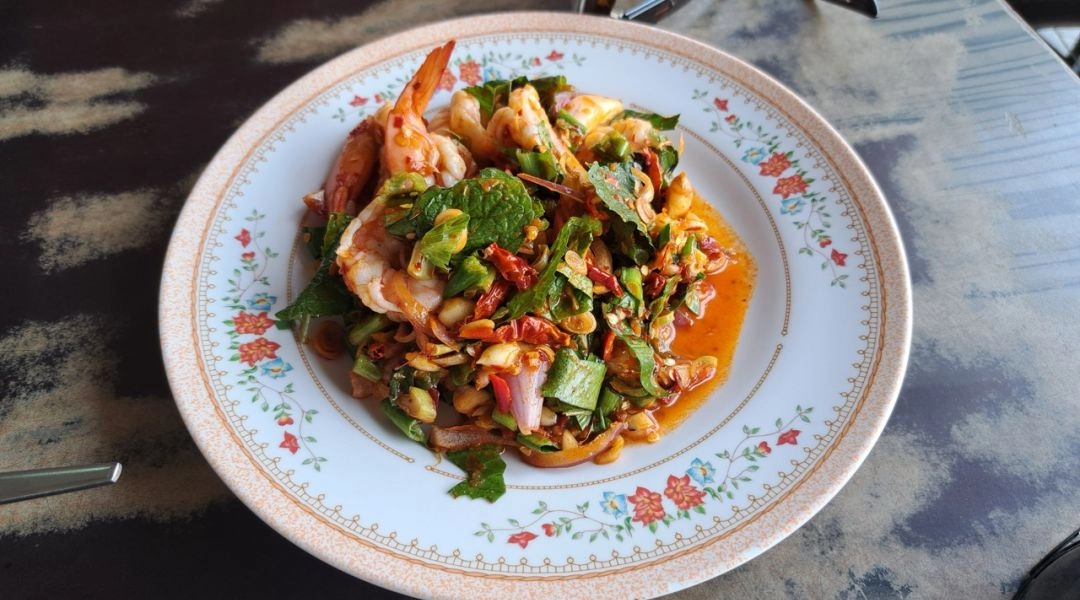 Tajska sałatka z krewetkami, ziołami i chilli, tradycyjne smaki kuchni Tajlandii.