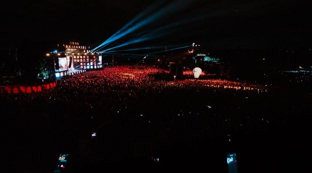 Nocny koncert plenerowy podczas Wianków nad Wisłą w Warszawie z dużą publicznością i oświetloną sceną.