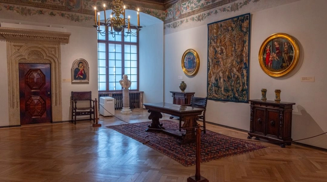 Zabytkowa komnata na Wawelu z drewnianym stropem, renesansowymi malowidłami, arrasem, obrazami i historycznymi meblami.