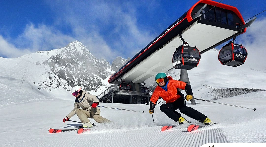 Narciarze na trasie w Tatrzańskiej Łomnicy, nowoczesna gondola i ośnieżone Tatry Wysokie zimą.