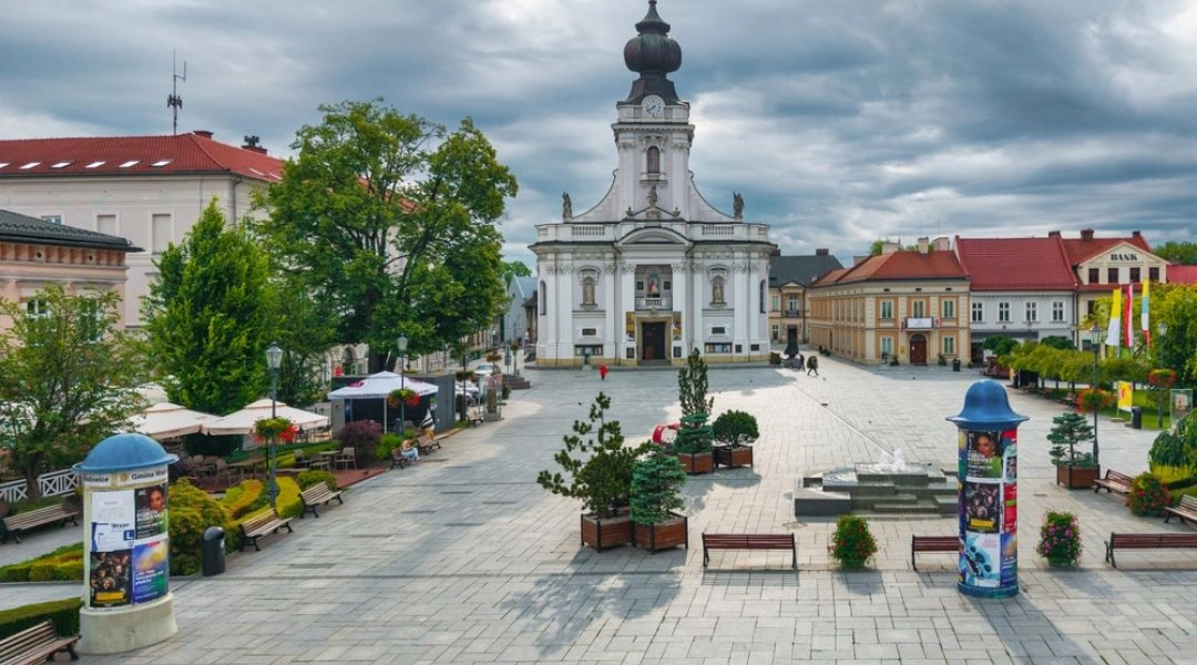 Rynek w Wadowicach z bazyliką Ofiarowania Najświętszej Maryi Panny, zabytkowymi kamienicami i ogródkami kawiarnianymi.