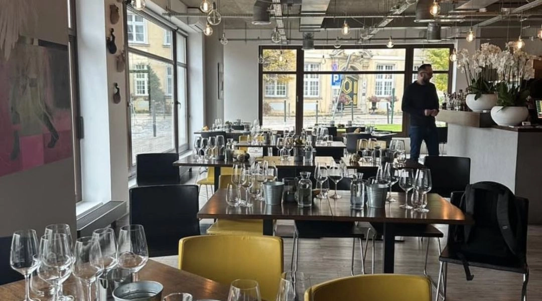 Wnętrze CityWine z przygotowanymi kieliszkami i nakrytymi stołami przed degustacją.