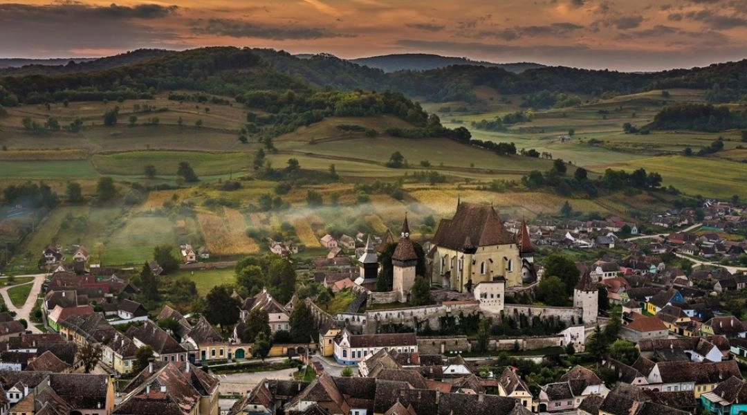 Panorama historycznej miejscowości w Transylwanii z warownym kościołem pośród wzgórz
